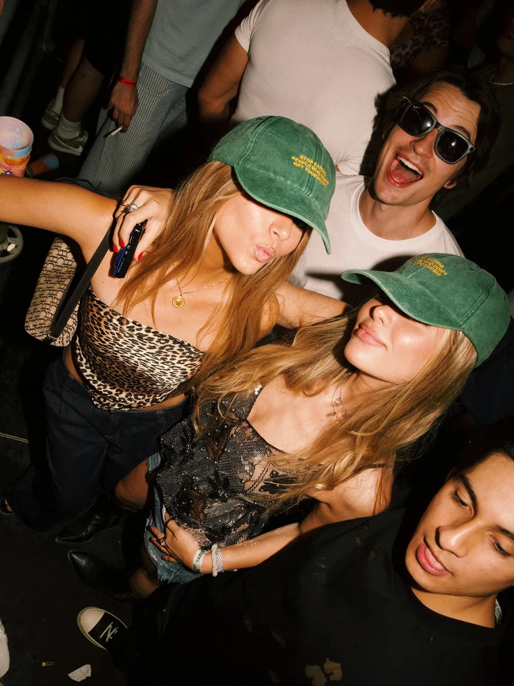 WANNA community wearing green statement caps at a party